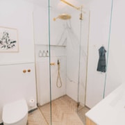 hvidt badeværelse med detaljer i guld og træ